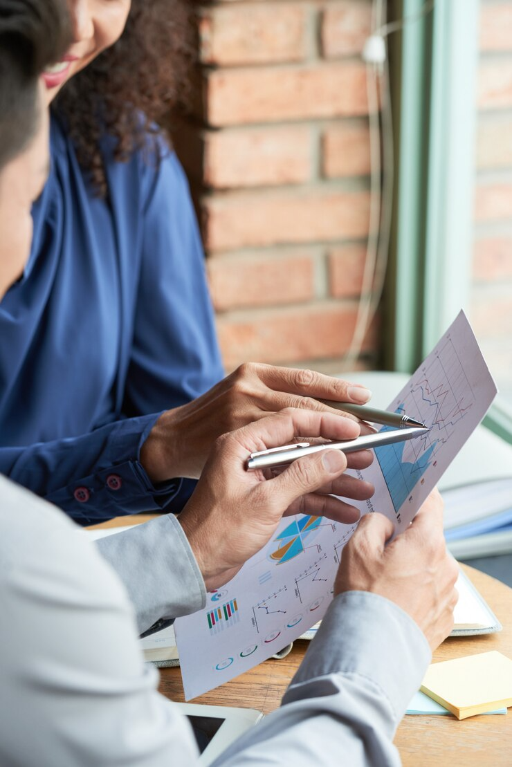 a biotech financial expert discussing graphs and charts on documents.